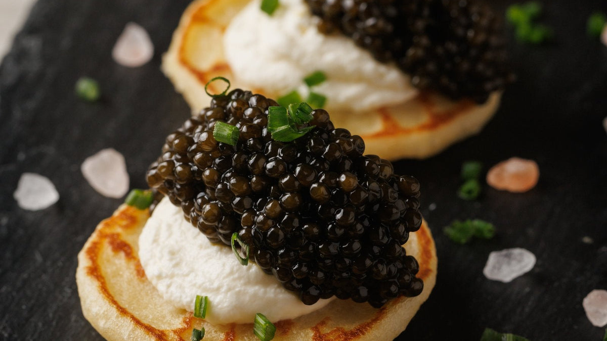 Classic caviar service - Attilus caviar on golden blinis with creme fraiche and chives