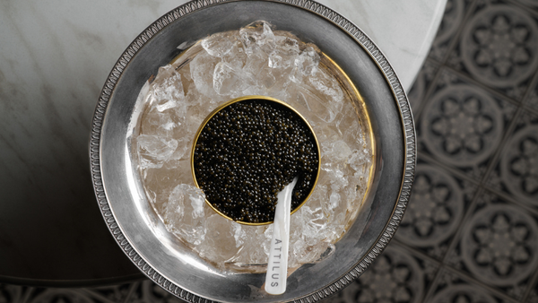 A refined caviar service at home with blinis, accompaniments and mother-of-pearl spoons.