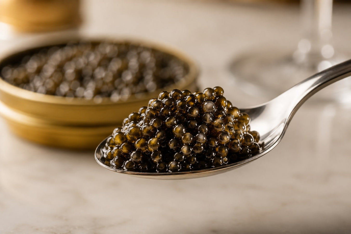 A heaped silver-coloured spoon of caviar in front of an open tin, illustrating one of the most common caviar mistakes — using a metal spoon.