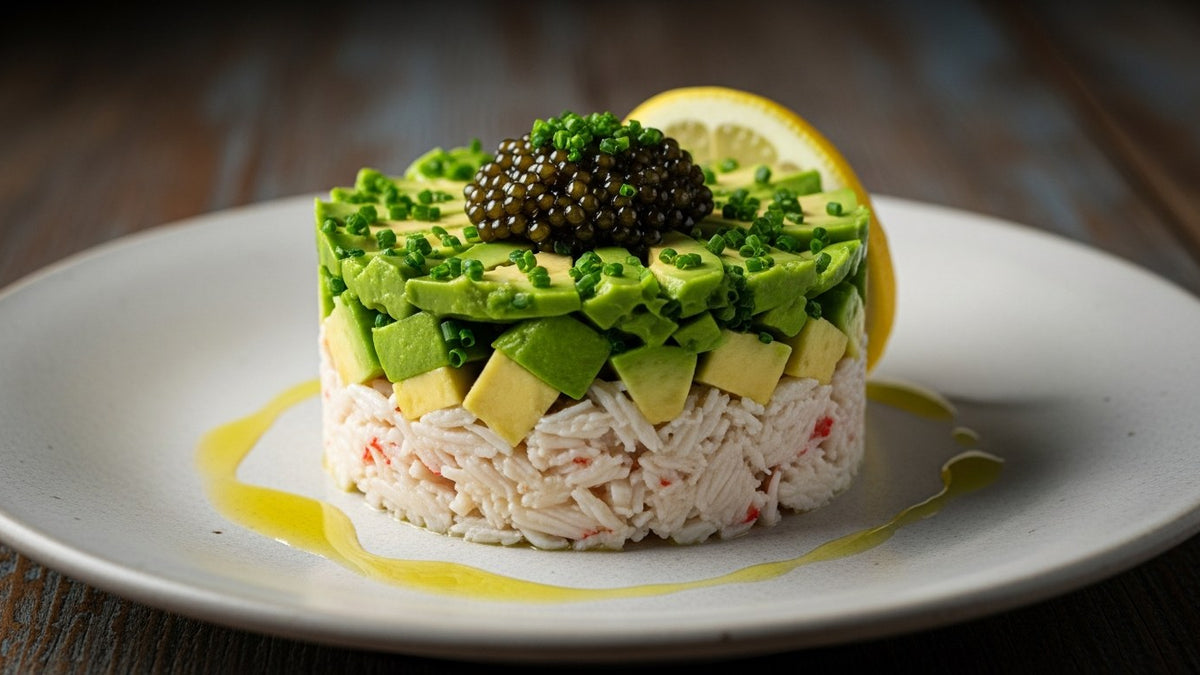 Layered crab and avocado tartare topped with a small spoonful of black caviar and chives